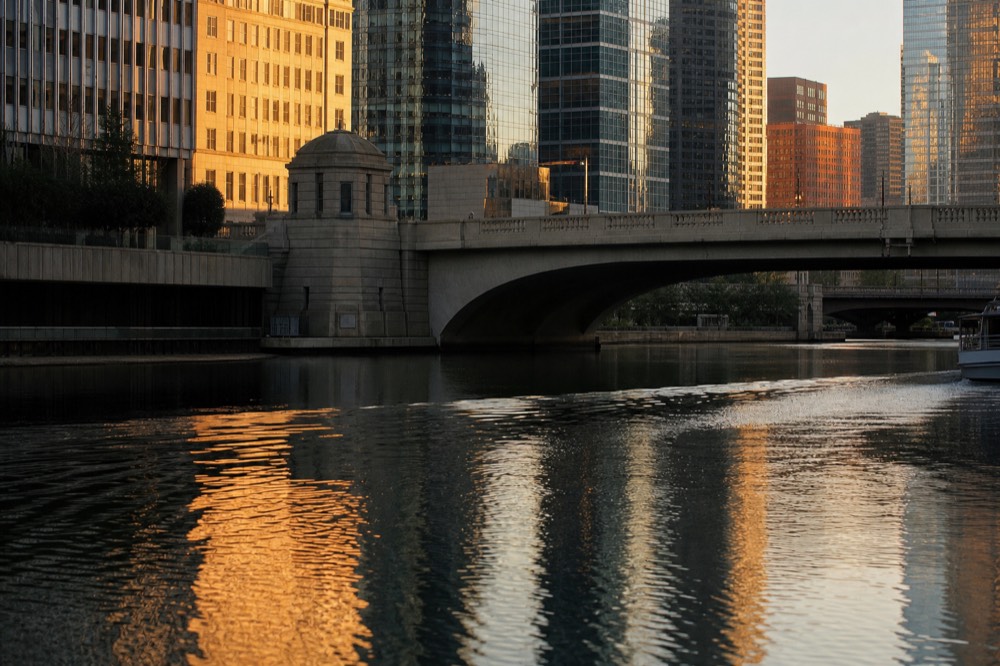 Downtown Chicago skyscrapers reflected in the Chicago River at golden hour, no text, no logos, no people