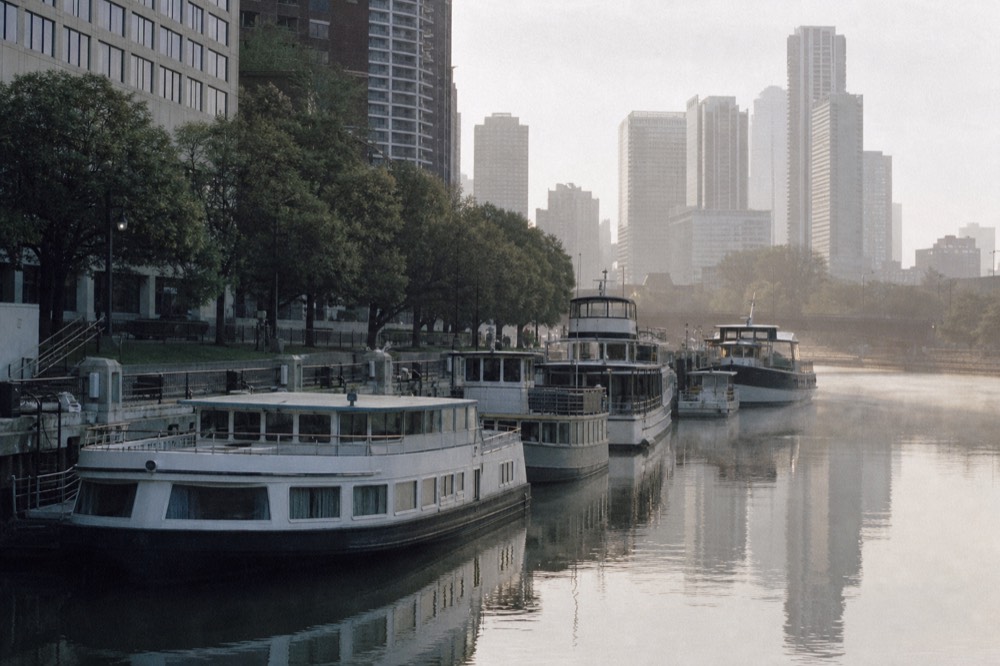 Riverwalk docks with architecture cruise boats moored along the Chicago River, no text, no logos, no people.