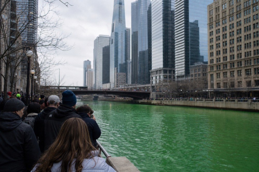 A tour boat moving along the Chicago River between downtown towers on a bright March morning, no text, no logos, no people.