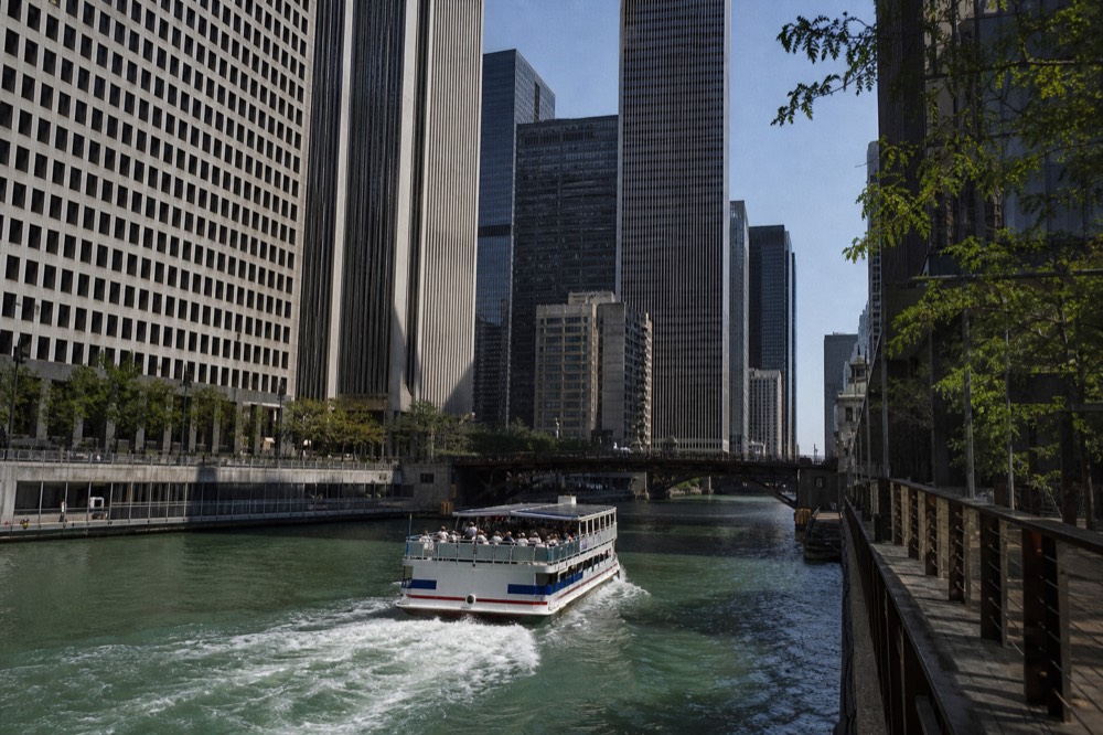 Architecture tour boat cruising the Chicago River between downtown towers, no text, no logos, no people